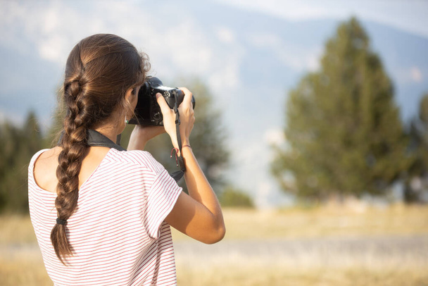 Biała nastolatka widziana z tyłu robiąca zdjęcia w lesie - Zdjęcie, obraz