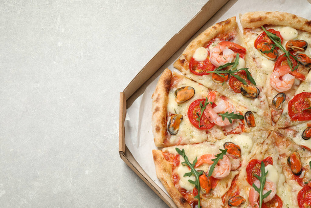 Delicious seafood pizza in box on light grey table, top view. Space for text - Valokuva, kuva