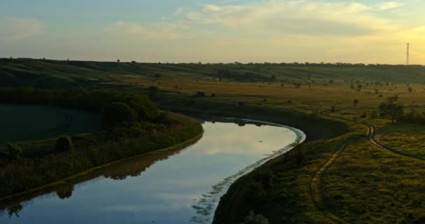 Ποταμός και πράσινο λιβάδι στο ηλιοβασίλεμα, θέα στον αέρα, όμορφο τοπίο - Πλάνα, βίντεο
