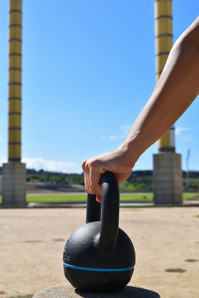 Main tenant une kettlebell, sport de plein air - Photo, image