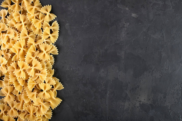 Raw Pasta, Spaghetti, Cannelloni, Farfalle, Campanella, Cavatappi, Conquilla, Fettuccine, Lasagna, Penne, Tagliatelle, on a black background - Photo, Image