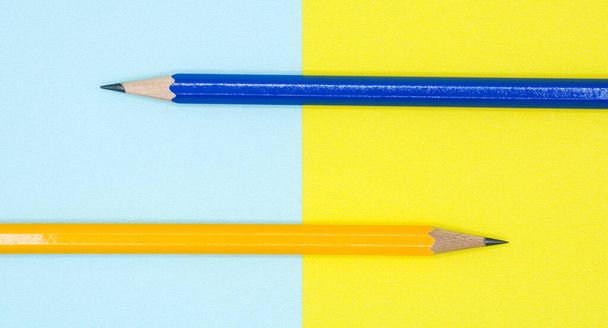yellow and blue pencil on blue and yellow paper - background - Photo, Image