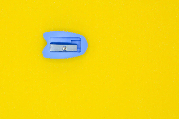 apontador de lápis de plástico azul no fundo amarelo
 - Foto, Imagem