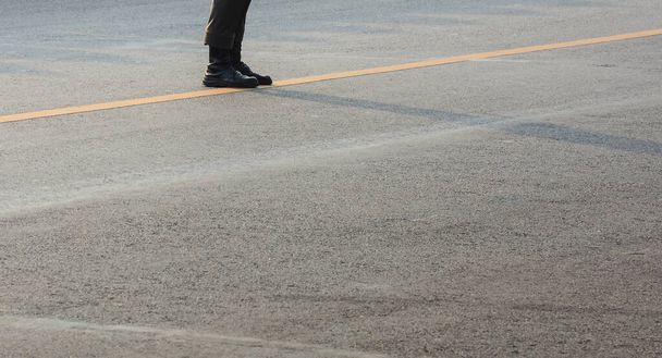 чоботи солдата, що стоять на асфальтній дорозі в місті
 - Фото, зображення