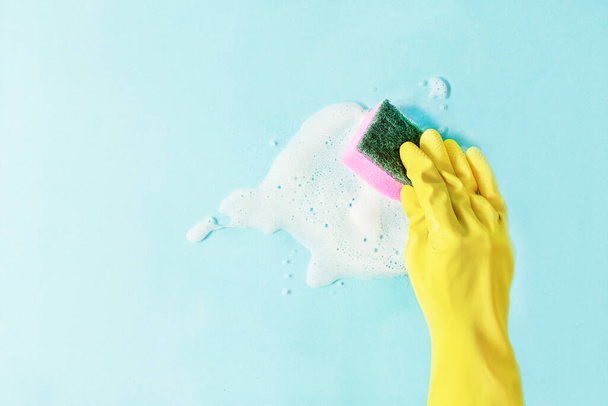 Hand in a rubber glove washing window with rag and detergent. Cleaning company concept. - Fotografie, Obrázek