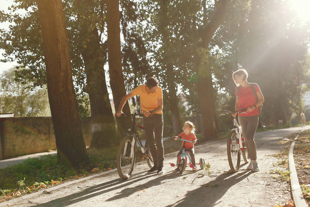 Familia con bicicleta en un parque de verano
 - Foto, imagen