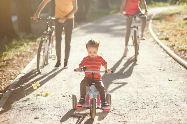 Family with a bicycle in a summer park - Photo, image