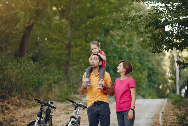 Family with a bicycle in a summer park - Foto, Imagen