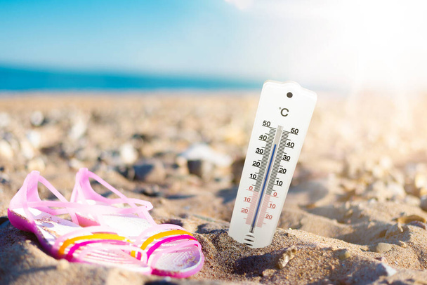 summer weather and hear concept with thermometer at beach - Photo, Image