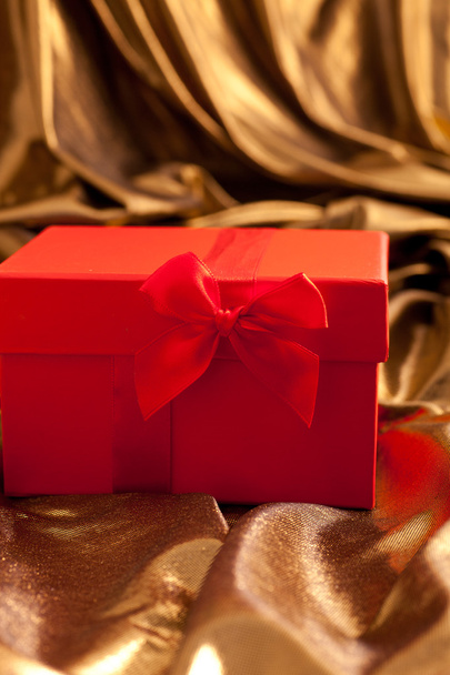 Red Valentines gift nestling in gold fabric - Φωτογραφία, εικόνα