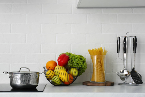 Kitchen counter with products, saucepot and utensils - Valokuva, kuva