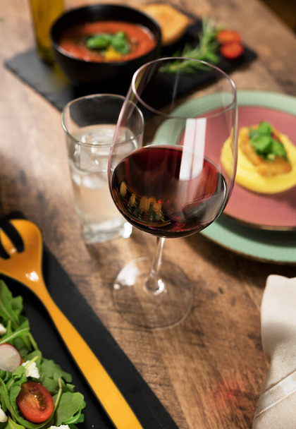 Стакан красного вина на столе в ресторане
. - Фото, изображение