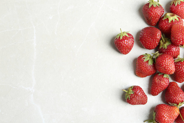 Delicious ripe strawberries on light grey marble table, flat lay. Space for text - Φωτογραφία, εικόνα