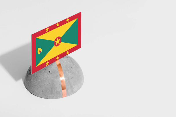 Grenada flag tagged on rounded stone. White isolated background. Side view minimal national concept. - Photo, Image