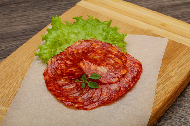 İtalyan geleneksel Chorizo domuz sosisleri fesleğen yaprağı servis ediyordu. - Fotoğraf, Görsel