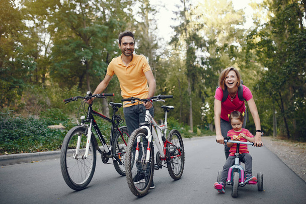 Family with a bicycle in a summer park - Photo, Image