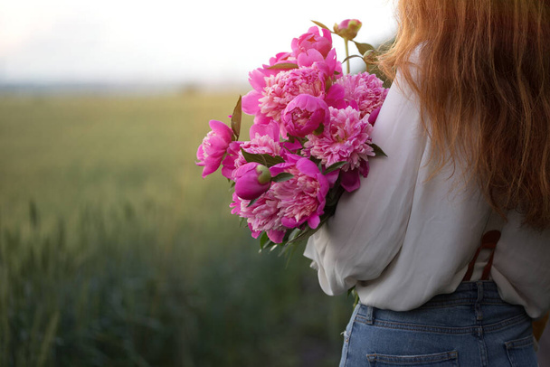 summer - Beautiful girl with a bouquet peony at the fiel - Фото, зображення