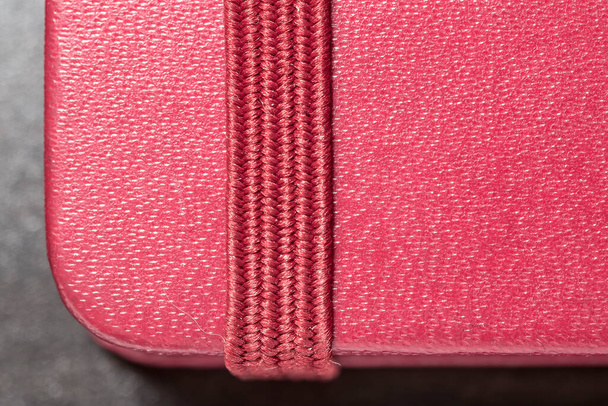 macro red notebook with bookmark, lying on a wooden table - Photo, Image