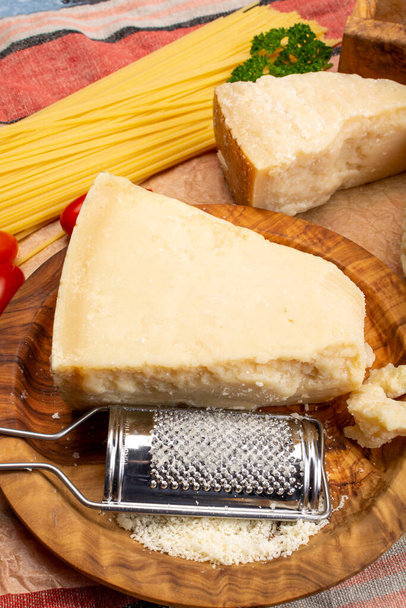 Приготування їжі з твердим італійським сиром, тертим пармезаном або сиром падано крупним планом
 - Фото, зображення