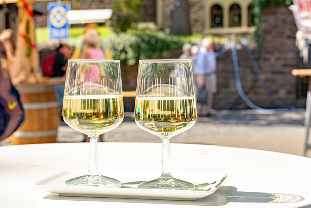 Дегустация холодного белого сухого вина Рислинг на фестивале уличных вин на реке Мозель, Германия, фестиваль урожая винограда
 - Фото, изображение