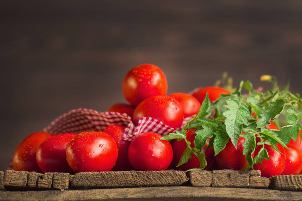 Concept de produit naturel. Tomates prunes longues fraîches avec serviette de cuisine à carreaux rouges. Aliments faits maison. - Photo, image