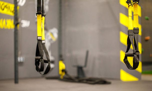 Trx straps in urban modern gym. A fitness equipment called trx that was prepared for playing at noon in a gym. - Φωτογραφία, εικόνα