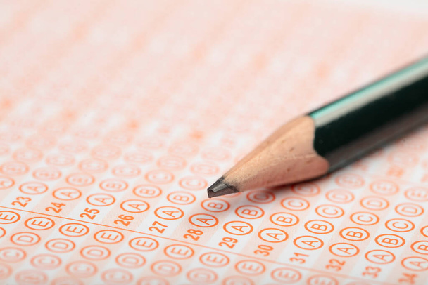 Uczniowie podchodzą do egzaminów, piszą egzamin trzymając ołówek na optycznej formie znormalizowanego testu z arkuszem odpowiedzi wykonując egzamin końcowy w klasie. Ocena edukacji Koncepcja. Miękkie skupienie  - Zdjęcie, obraz