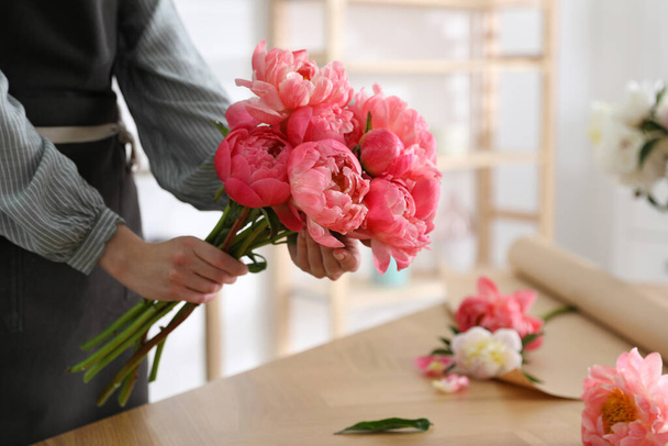 Florist making beautiful peony bouquet at table, closeup - Foto, Imagen