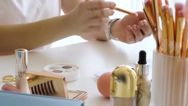 Make-up kunstenaar met decoratieve cosmetica werken aan tafel, close-up - Video