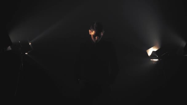 Homme en noir dans les rayons lumineux et la fumée - Séquence, vidéo
