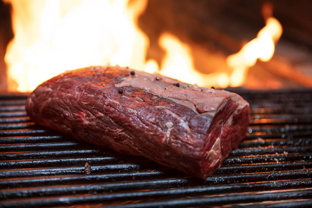 grilling steaks on flaming grill and shot with selective focus. - Photo, Image