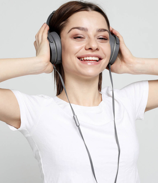 Beautiful young woman listening to music in headphones - Fotoğraf, Görsel