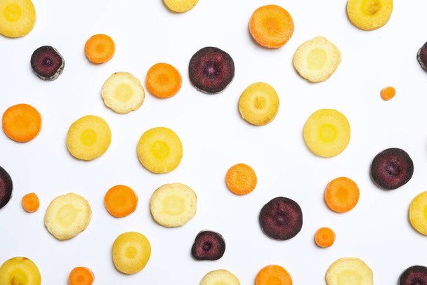 Slices of raw color carrots on white background, top view - Photo, image