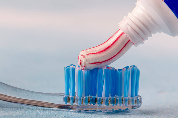 Zubní kartáček a zubní pasta na rozmazaném pozadí  - Fotografie, Obrázek