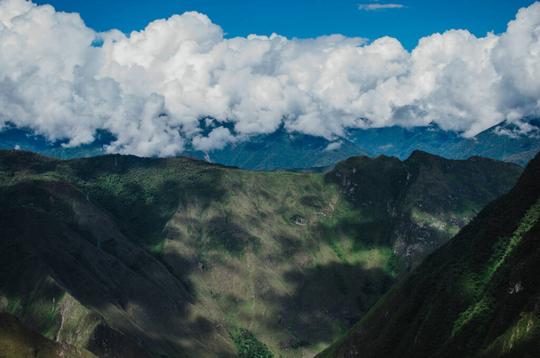 Stock photo of a mountain landscape. The sky is cloudy and covers the mountains in the background. - 写真・画像