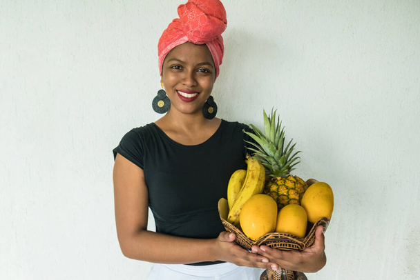 Ευτυχισμένη Λατίνα που κουβαλάει καλάθι με φρούτα - Φωτογραφία, εικόνα