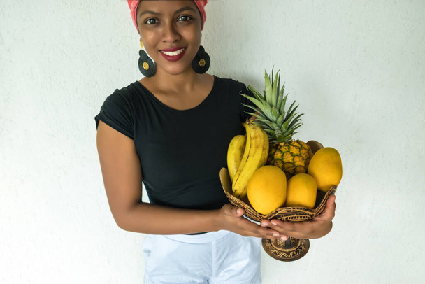 Heureuse fille éthiopienne portant un panier de fruits - Photo, image