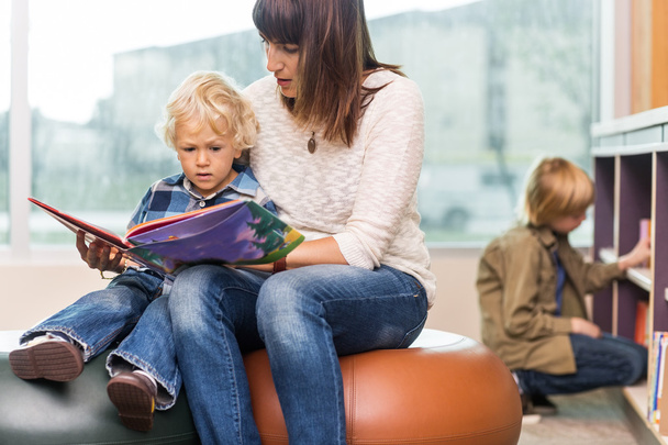 Teacher With Boy Reading Book In Library - Zdjęcie, obraz