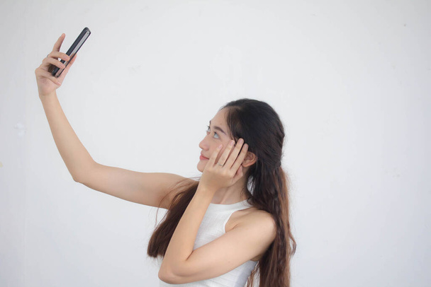 Portret tajskiej porcelany dorosła piękna dziewczyna Biała koszula niebieskie dżinsy za pomocą smartfona Selfie - Zdjęcie, obraz