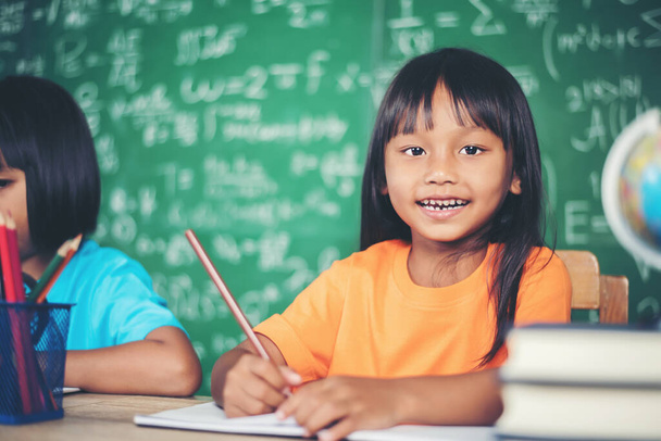 Две девушки с карандашом на уроке в классе
  - Фото, изображение