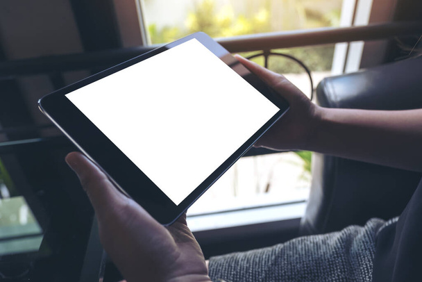 Mockup-Bild der Hände hält schwarzen Tablet-PC mit weißen leeren Bildschirm  - Foto, Bild