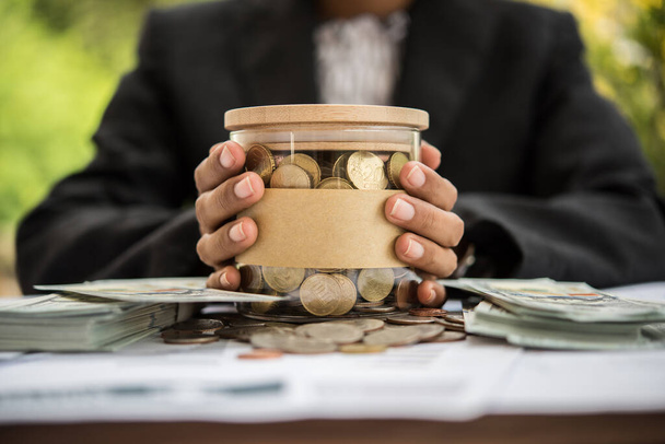 Saving Money  putting coins into a jar. - Photo, Image