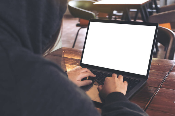 Макет зображення людини, яка використовує і друкує в ноутбуці з порожнім білим екраном робочого столу на дерев'яному столі в кафе
 - Фото, зображення