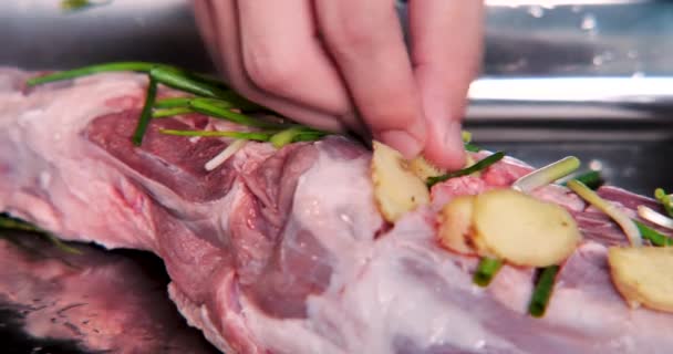 Seasoning raw lamb leg with garlic, onions,  lemon, ginger. Cooking concept, on a dark background. - Footage, Video