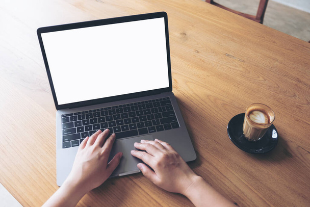 Макет зображення жінки з ноутбуком з порожнім білим екраном робочого столу з чашкою кави на дерев'яному столі
  - Фото, зображення