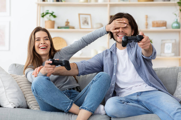 Excitable man and woman playing video games at home - Photo, Image