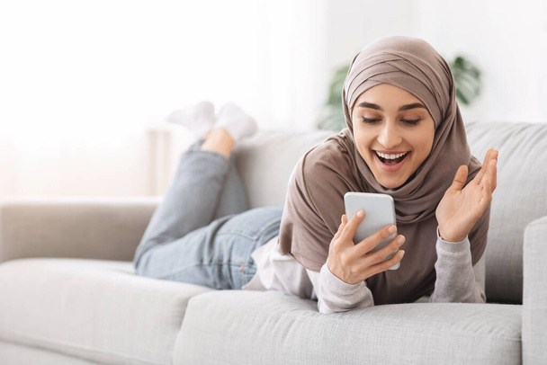 Message inattendu. Femme arabe excitée tenant Smartphone et criant avec joie - Photo, image