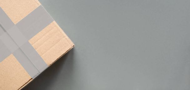 Delivery concept. Cardboard package box closed and sealed on grey background - Fotoğraf, Görsel