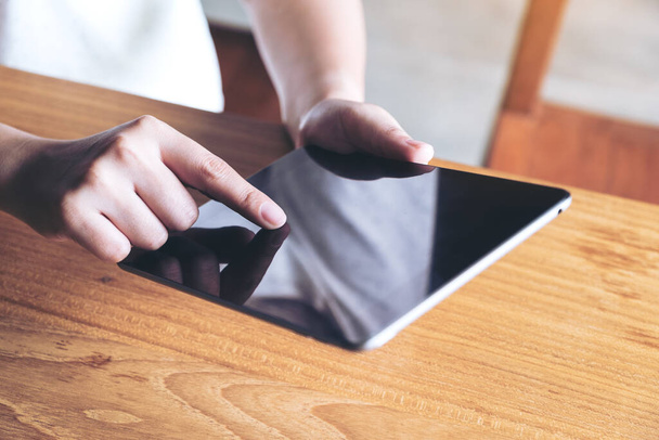 Nahaufnahme von Händen, die einen Tablet-PC in einem modernen Café halten, benutzen und berühren - Foto, Bild
