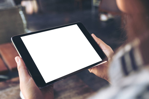 Mockup image of a woman holding and using black tablet pc with white blank screen  - Photo, Image
